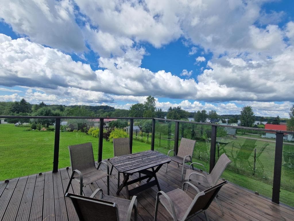 Terrace with a table and chairs overlooking the countryside and lake
